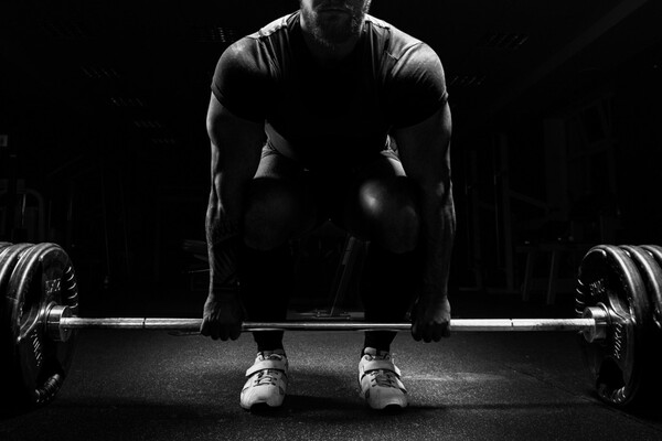 Erwachsene Person streckt die Arme über dem Kopf im Sitzen an einem Schreibtisch